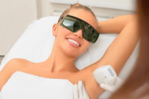 Laser hair removal cosmetology procedure from a therapist at cosmetic beauty spa clinic. Laser epilation underarm. Cosmetology and SPA concept.