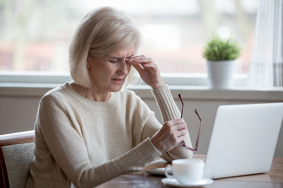 Upset fatigued overworked senior mature business woman taking off glasses