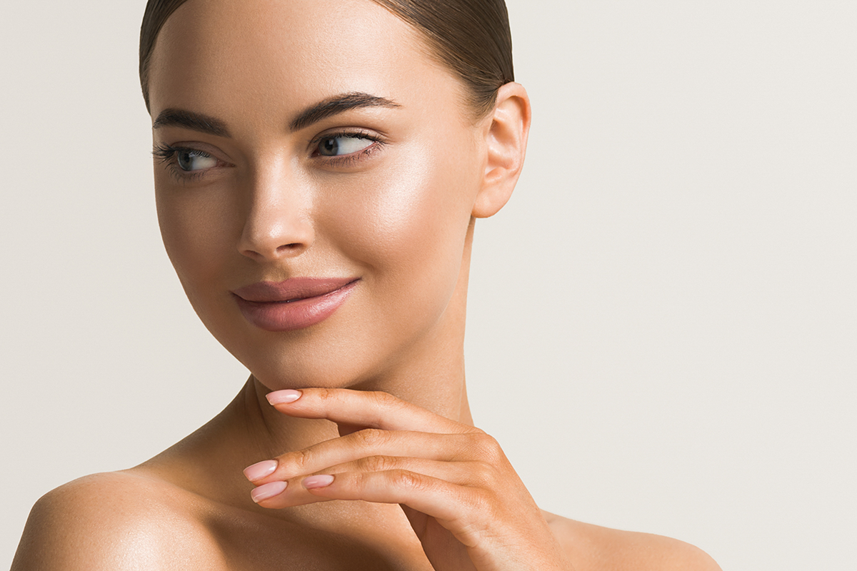 beautiful woman face close up natural make up hand touching face