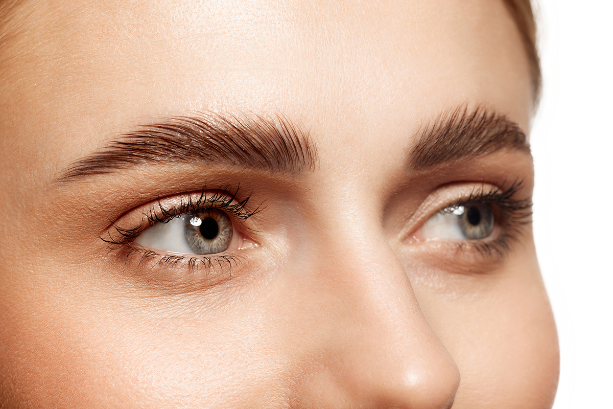Close-up of beautiful clear female face with perfect eyebrows and natural lashes