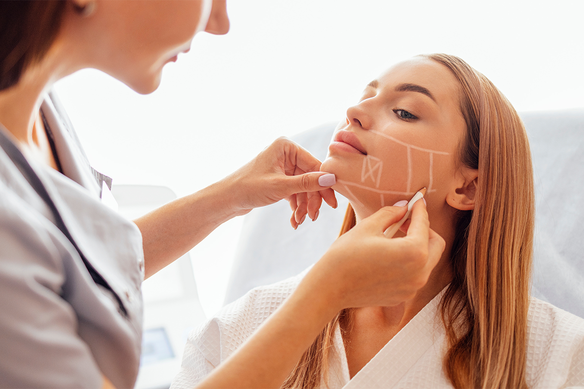 Plastic surgeon checking woman face skin in cosmetology clinic before plastic surgery Plastic surgeon checking woman face skin in cosmetology clinic before plastic surgery