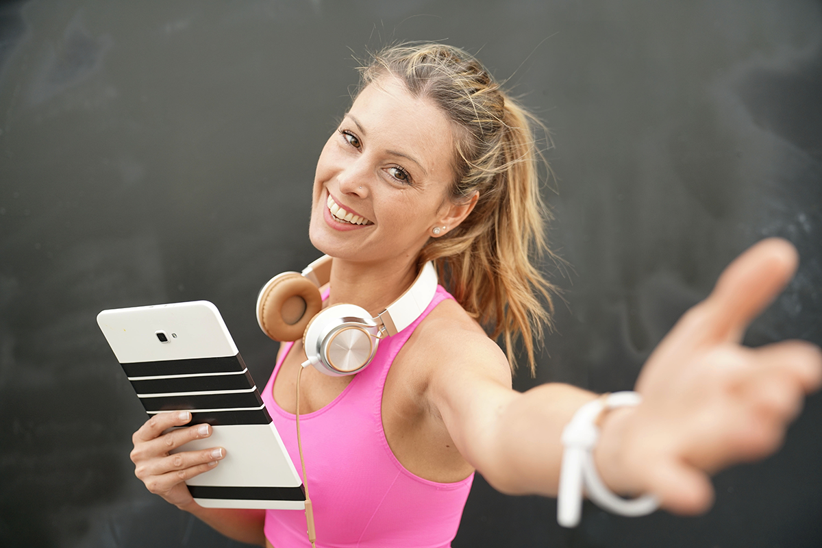 Happy fitness instructor with tablet