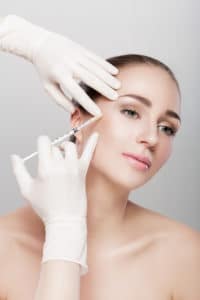 woman getting injection into cheek woman getting injection into cheek