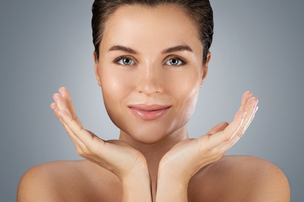young beautiful woman with perfect skin on gray background young beautiful woman with perfect skin on gray background
