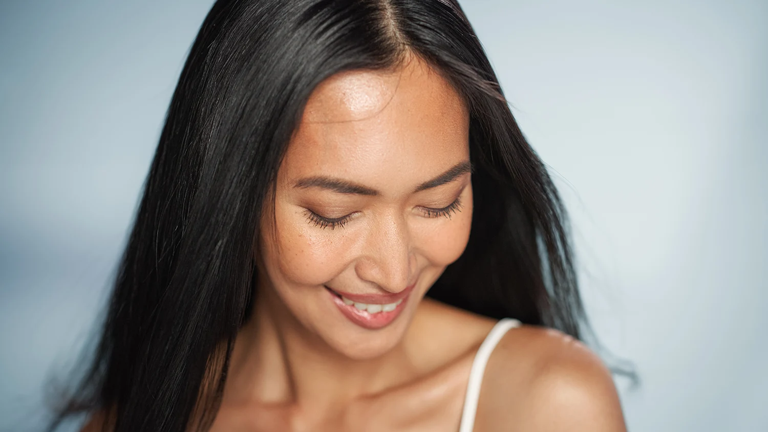 Smiling woman with eyes closed and long dark hair Smiling woman with eyes closed and long dark hair